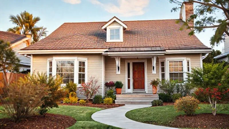 A photorealistic image of a secure, well-maintained home with a newly installed impact-resistant roof, reinforced windows, and a well-landscaped, fire-resistant yard. The scene is bright and professional, showcasing resilience, 8K, cinematic lighting, sharp focus, depth of field, shot on a high-end DSLR.